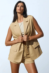 a woman in a tan blazer and shorts