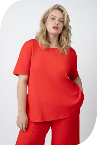 Plus-size model wearing a red CoolROSE™ Luxe Oversize Tee with relaxed shoulders and longer sleeves for a chic, balanced look.