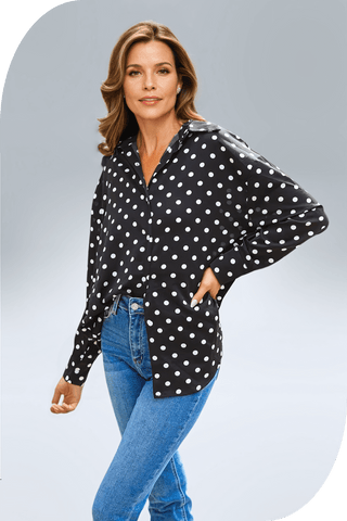 Woman wearing a classic polka-dot button-up blouse with a relaxed, true-to-size fit and button-front closure, paired with blue jeans.