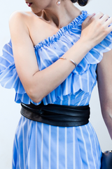 a woman wearing a blue dress and a black belt