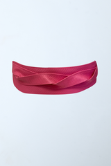 a close up of a pink ribbon on a white background